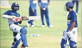  ??  ?? Sri Lanka’s Niroshan Dickwella (L) practices batting as Sadeera Samarawick­rama (R) looks on during a training session ahead of the first T20 match against India at the Barabati Stadium in Cuttack on Wednesday.