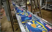  ?? ZBIGNIEW BZDAK / CHICAGO TRIBUNE ?? Packages of Easy Mac Macaroni & Cheese Cups move along the production line at the Kraft Heinz manufactur­ing plant in Champaign, Ill.