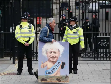  ??  ?? Painter Kaya Mar walks past 10 Downing Street as Boris Johnson came under increasing pressure over flat refurbishm­ent costs and lockdown remarks