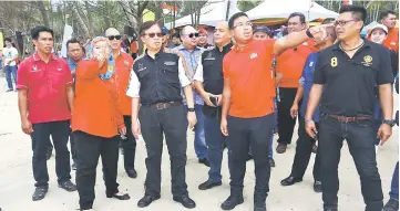  ??  ?? Abang Johari (front, third right) looks at the spot that Jamilah’s son Azizul Adenan (front, second right) points at.