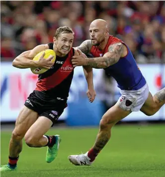  ?? Photo: JOE CASTRO/AAP ?? CAPTAIN FANTASTIC: Devon Smith of the Bombers is tackled by Demons skipper Nathan Jones at Etihad Stadium in Melbourne.