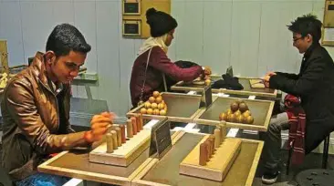  ??  ?? (From left) Muhammad Haris danial Mohd anwar, Nur Fatihah athira Muhamad and amir Fariq anuar taking a closer look at the exhibits at the tom tits experiment, Stockholm.