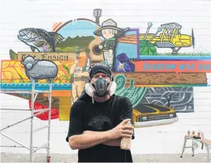  ?? PHOTO: FIONA ELLIS ?? Can do . . . Artist Sean Duffell takes a quick break while apply the finishing touches to his Tower Lane mural in Gore on Friday.