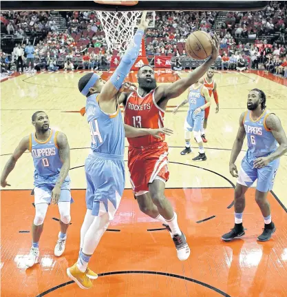  ??  ?? The Rockets’ James Harden goes up for a shot as the Clippers’ Tobias Harris defends.