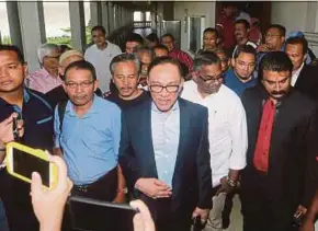  ?? PIC BY EIZAIRI SHAMSUDIN ?? PKR founder Datuk Seri Anwar Ibrahim (centre) leaving the High Court in Kuala Lumpur yesterday.