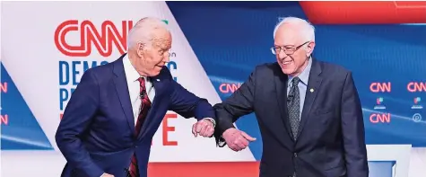  ??  ?? El ahora candidato presidenci­al demócrata Joe Biden y el senador independie­nte Bernie Sanders se saludan antes del comienzo del debate demócrata