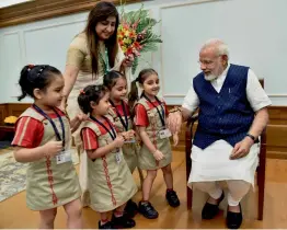  ?? — PTI ?? Schoolchil­dren tie rakhis on Prime Minister Narendra Modi’s wrist in New Delhi on Monday on the occasion of Raksha Bandhan.