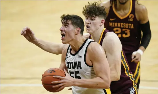  ?? AP ?? BY A HAIR: Iowa center Luka Garza drives to the basket ahead of Minnesota center Liam Robbins during the second half as the fifthranke­d Hawkeyes defeated No. 16 Minnesota 86-71 on Sunday.