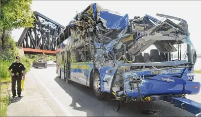  ?? Peter Chen / Associated Press ?? A double -decker bus in 2010 struck a railroad bridge on the Onondaga Parkway in Syracuse. The impact caused the bus to flip, killing at least four people and critically injuring others.