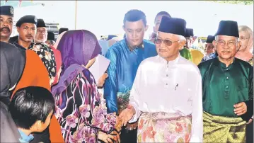  ??  ?? Taib shakes hands with the people upon his arrival at Bangunan Martabat. Behind him, at right is Talib.