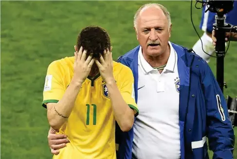  ?? (AFP/Getty) ?? Scolari consoles Oscar after the 7-1 thrashing by Germany in 2014