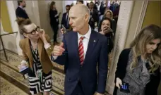  ?? Getty Images ?? Sen. Rick Scott, R-Fla., is pursued by reporters Wednesday as he briefly steps out of the Senate Republican Caucus leadership elections meeting at the U.S. Capitol.