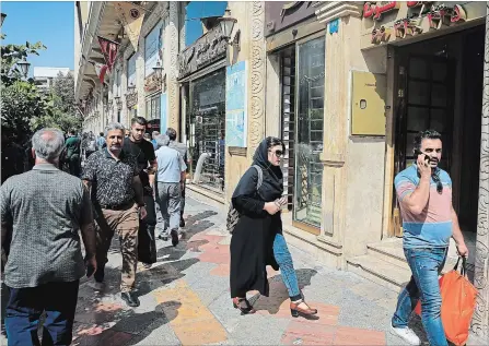  ?? EBRAHIM NOROOZI THE ASSOCIATED PRESS ?? People walk in front of a currency exchange shop in downtown Tehran, Iran, Wednesday, Sept. 5, 2018.