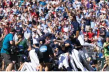  ?? REBECCA S. GRATZ/ASSOCIATED PRESS ?? Mississipp­i’s Jack Washburn, right, leaps on top of the team pile in celebratio­n of the Rebels’ 4-2 victory over Oklahoma in Game 2 of the NCAA College World Series finals Sunday in Omaha, Neb.