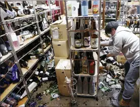  ?? JUN HIRATA/KYODO NEWS VIA ASSOCIATED PRESS ?? A liquor shop’s manager clears the damaged bottles following an earthquake in Fukushima, northeaste­rn Japan Saturday.