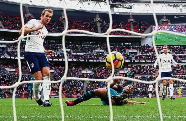  ??  ?? Triple treat: Tottenham Hotspur’s Harry Kane (left) scoring one of his three goals in the English Premier League match against Southampto­n at Wembley yesterday. — AFP