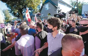  ?? NATHAN DENETTE LA PRESSE CANADIENNE ?? Le chef libéral et des journalist­es ont soutenu avoir reçu de petites roches, lancées par la foule en colère, lundi, à London, alors que M. Trudeau s’apprêtait à monter dans son autobus de campagne.