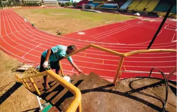  ?? (SUN.STAR FOTO/ALEX BADAYOS) ?? BRAND NEW. A worker puts on the finishing touches on the stairs to the giant urn at the CCSC. Cebu City will host the Prisaa national meet next week, which will also be the first time the new track oval will be used.