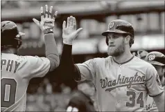  ?? Matt Rourke / The Associated Press ?? Washington’s Bryce Harper (right) celebrates with teammate Daniel Murphy after hitting a two-run home run in the first inning of Friday’s game.