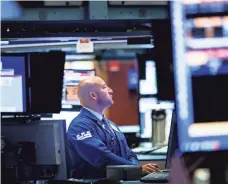  ?? JUSTIN LANE/ EPA-EFE ?? Low costs are a big reason investors are flocking to ETFs. Above, a trader works at the NYSE in July.