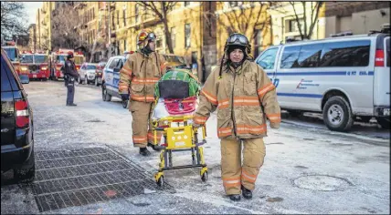  ?? AP Photo ?? Police stand guard as paramedics leave the scene near the building Friday, Dec. 29, 2017, where more than 10 people died in a fire on Thursday, in the Bronx borough of New York.