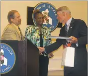  ??  ?? Scott Hancock, executive director of the Maryland Municipal League and Tracy Gant, MML president and mayor of the Town of Edmonston, honor La Plata Mayor Hale with a citation and a gift at Town Hall on April 25.