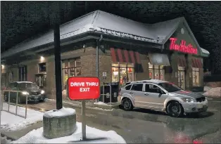  ?? CP PHOTO ?? A customer stops their car at a Tim Hortons drive-thru window in Newcastle, Ont., on Sunday.