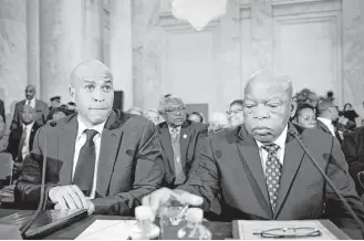  ?? Cliff Owen / Associated Press ?? New Jersey U.S. Sen. Cory Booker, left, broke with Senate tradition by testifying against a fellow senator, while Rep. John Lewis urged the committee to focus on Sen. Jeff Sessions’ views on race.