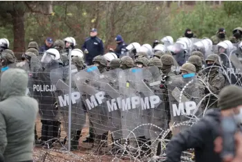  ?? — AFP file photo ?? Poland’s law enforcemen­t officers watching migrants at the Belarusian-Polish border.