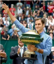  ?? — AFP — AFP ?? Roger Federer with the trophy in Halle on Sunday.