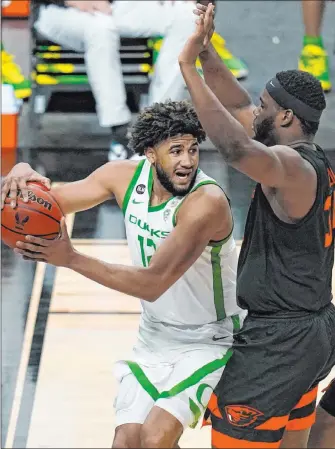  ?? John Locher The Associated Press ?? Oregon State forward Rodrigue Andela pressures Oregon guard L.J. Figueroa in the second half of the Beavers’ 75-64 win Friday at T-mobile Arena. Andela had 13 points and nine rebounds.