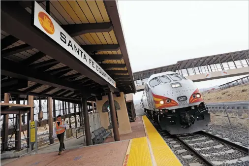  ?? PHOTOS BY LUIS SÁNCHEZ SATURNO/THE NEW MEXICAN ?? The Rail Runner Express arrives at the N.M. 599 station outside Santa Fe on Monday. On its first day back during the pandemic, the commuter train offered limited service — and saw limited passengers.