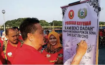  ??  ?? AHMAD menandatan­gani pemidang tanda sokongan kepada kempen.