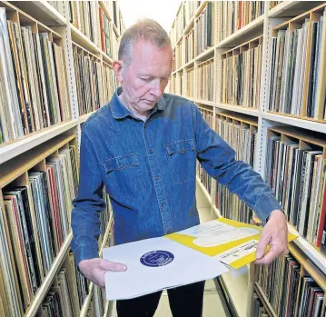  ?? REUTERS ?? Andy Linehan, curator of popular music recordings at the British Library, checks a limited edition pressing of Mendelssoh­n’s Violin Concerto in E Minor 1948 recording — the very first 33rpm vinyl LP to be issued — before it is added into the library’s...