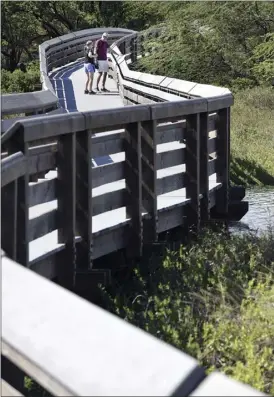  ?? The Maui News / MATTHEW THAYER photo ?? A couple visiting from Scotland explores the Kealia Pond National Wildlife Refuge on the Kealia Coastal Boardwalk on Tuesday afternoon. The visitor center was closed Monday due to the federal government shutdown but reopened Tuesday. The boardwalk is...