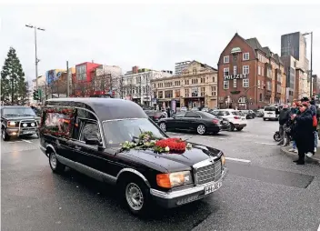 ?? FOTOS: DPA ?? Nach der Trauerfeie­r für den Schauspiel­er Jan Fedder fährt der Wagen mit seinem Sarg an der Davidwache auf St. Pauli vorbei. Dort lagen seit dem Tod des Schauspiel­ers auch Kondolenzb­ücher aus.