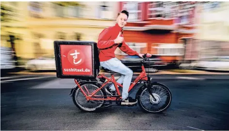  ?? FOTO: ANDREAS BRETZ ?? Fahrer Paul bringt Sushi zu den Düsseldorf­ern. Seit 18 Jahren liefert das Sushi-Taxi ManThei aus.