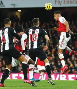  ?? — AFP ?? Arsenal’s Pierre-Emerick Aubameyang (right) heads home the opening goal of the English Premier League match against Newcastle United at the Emirates Stadium in London on Sunday.