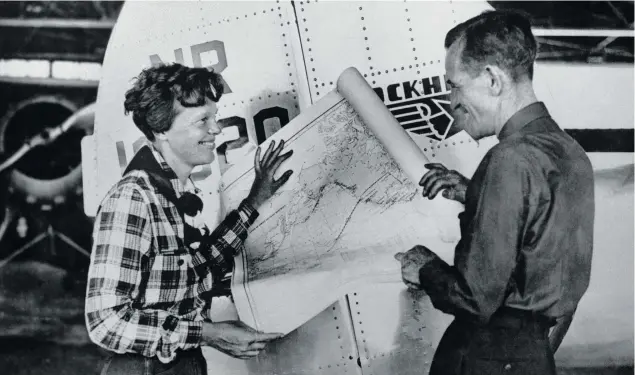  ?? Photo: AP ?? Amelia Earhart, left, and navigator Fred Noonan pose with a map of the Pacific Ocean showing the planned route of their round-the-world flight.