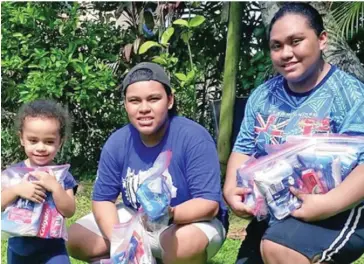  ??  ?? AnneMary Raduva (right) with her siblings holding the dignitary packs.