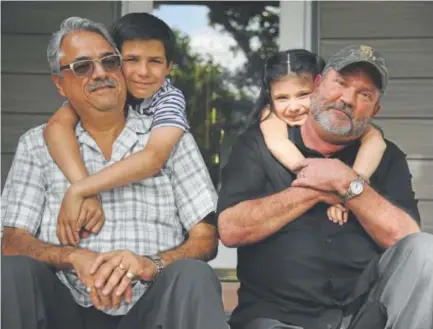  ?? .John Leyba, The Denver Post ?? Vince Montez, left, and his husband, Quentin, join their two adopted kids, 11-year-old Marcus and 5-year-old Auriah, on the front porch of their house near Fort Logan on Thursday, prior to going to see the Rockies at Coors Field.