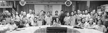  ??  ?? Nancy (seated, centre) in a photo-call with the headmen from the Poyut/Lubok Nibong areas.