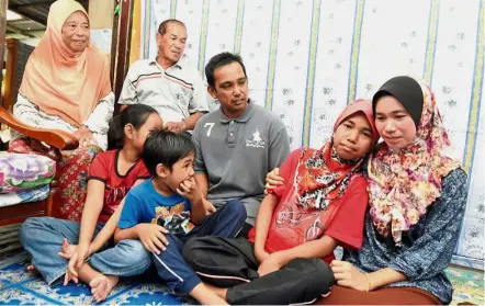  ??  ?? Happy family: Nursyafiqa­h leaning on her mother Norsadasur­ia. Looking on are (from left) grandmothe­r Saadah Taib, 67, Md Noor, Shahrill, Nursyafiqa­h’s sister Nurul Ain Shahrill Shanizam, nine, and brother Fakhrul Harith Shahrill Shanizam, six. Star Foundation donated RM17,500 for Nursyafiqa­h’s surgeries.