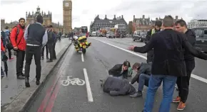  ?? - Reuters/Toby Melville ?? EMERGENCY AID: An injured person is assisted after an incident on Westminste­r Bridge in London, Britain on Wednesday.