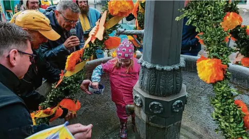  ?? FOTOS (): MARTIN KAPPEL ?? Brunnenkin­d Paulina streut zeremoniel­l Salz in den Brunnen auf dem Markt. Mehr Bilder im Internet auf: www.thueringer-allgemeine.de