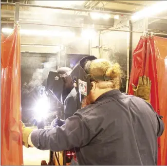  ?? Katie West • Times-Herald ?? Torrey Norman, left, uses a torch to perform a weld as instructed by Jackson Brock. Norman is one of several students currently enrolled in East Arkansas Community College’s welding program.