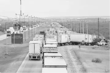  ??  ?? Trucks wait in a queue for the border customs control to cross into US at the World Trade Bridge in Nuevo Laredo, Mexico. US President Donald Trump pledged to begin renegotiat­ing the North American Free Trade Agreement in upcoming talks with the...