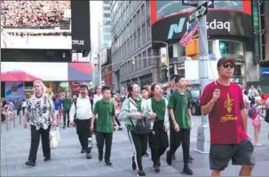  ?? PHOTOS BY LIAO PAN / CHINA NEWS SERVICE ?? Above and left: Chinese visitors enjoy Times Square in New York. China is the third-largest source of overseas travel to the United States, producing 3.2 million visitors in 2017 and accounting for 8.2 percent of all overseas travel to the country.