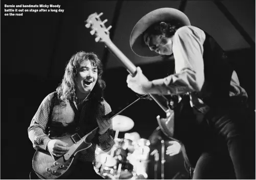  ??  ?? Bernie and bandmate Micky Moody battle it out on stage after a long day on the road