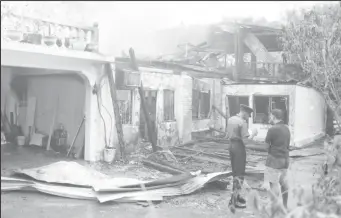  ??  ?? The charred remains of the three-storey building on Main Street yesterday morning where well-known businessma­n Yusuf Sankar perished in a fire.